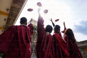 Un grupo de graduados lanzando sus gorras al aire