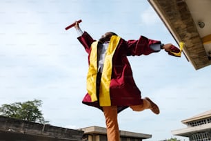 a man in a graduation gown jumping in the air