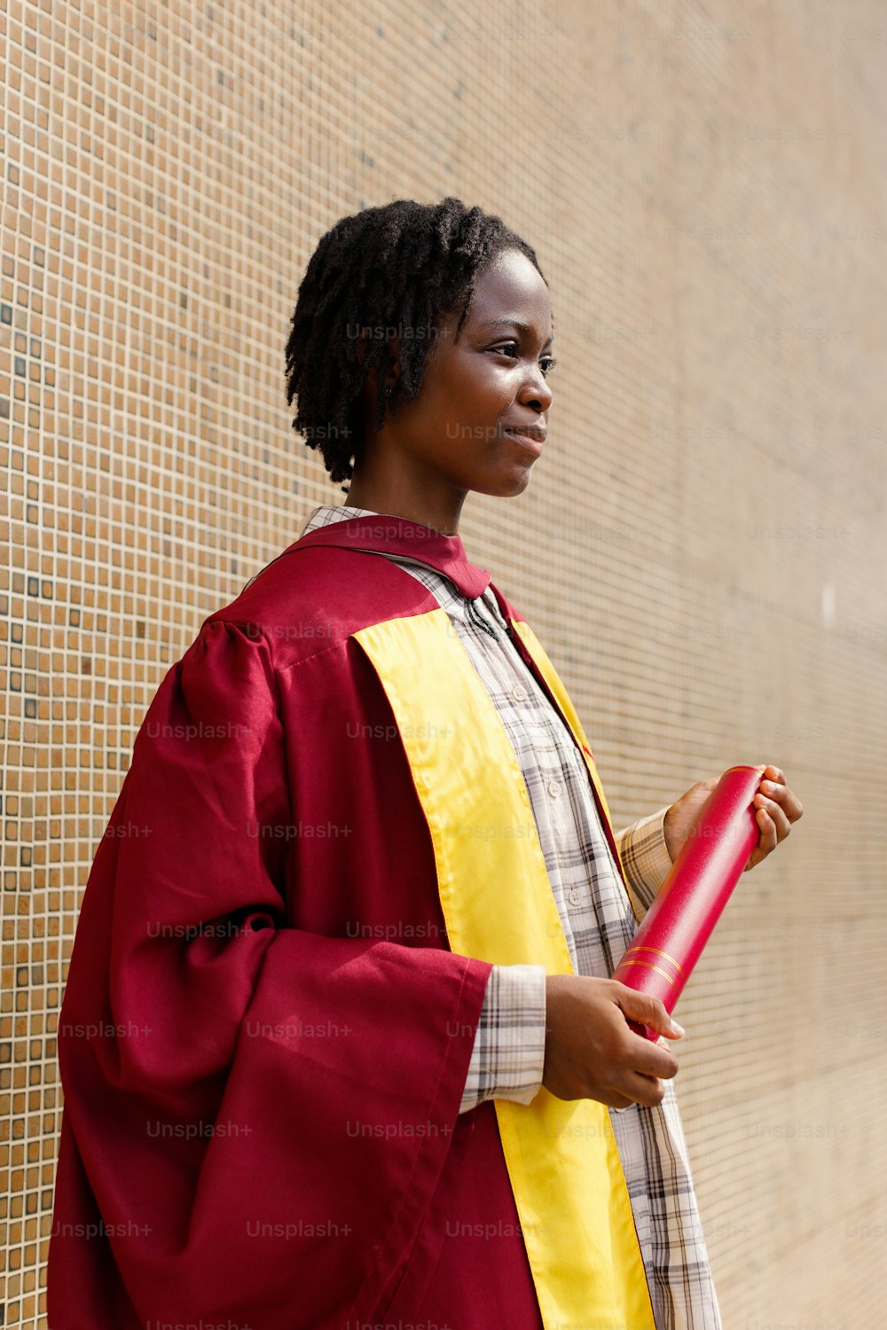 a woman in a red and yellow graduation gown