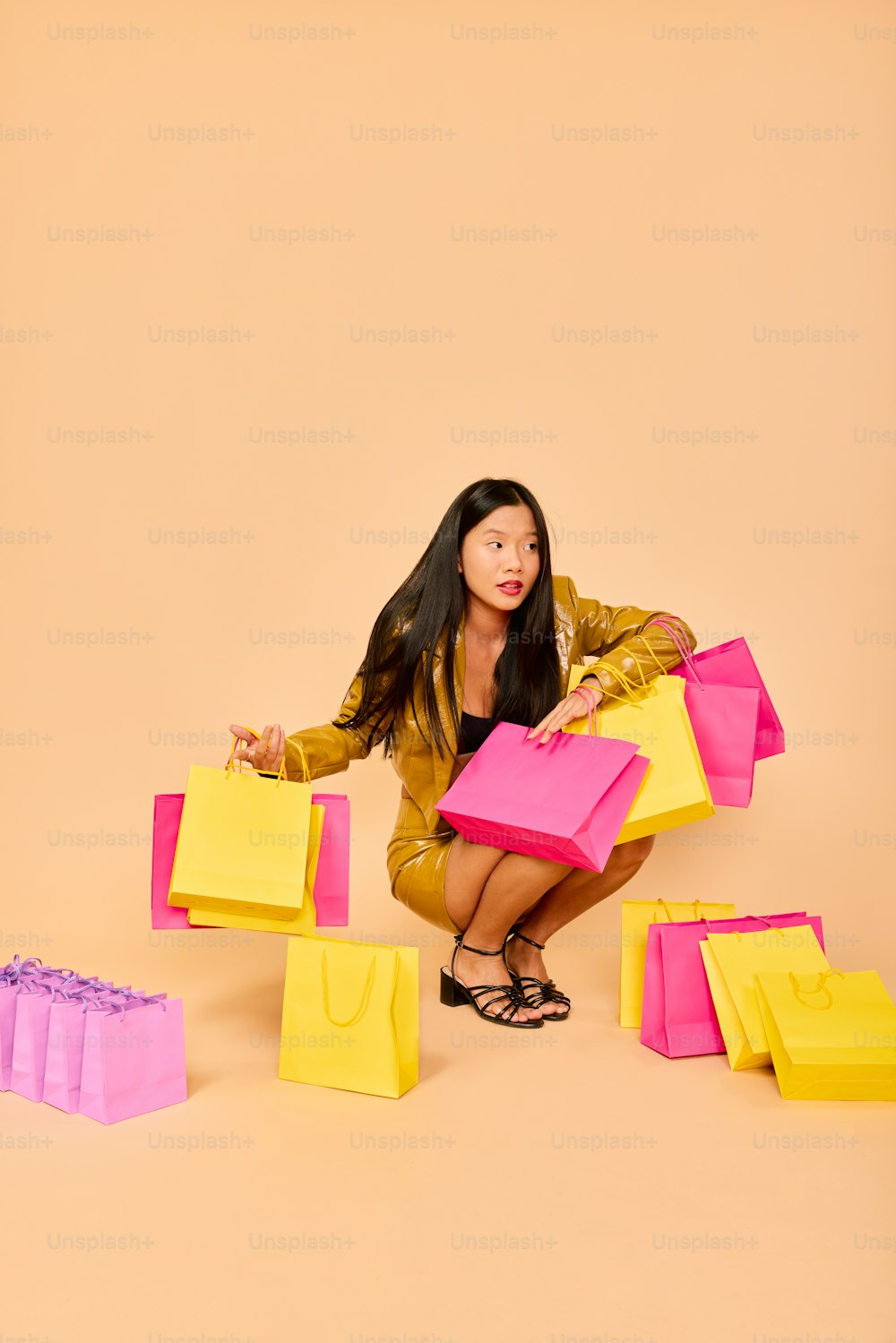 a woman kneeling on the ground holding shopping bags