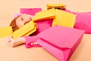 una donna sdraiata a terra con un sacco di borse della spesa