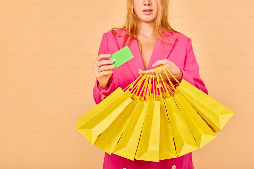 a woman in a pink suit holding a green card