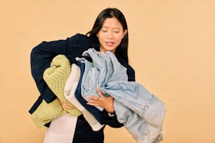 a woman holding a pile of clothes in her hands