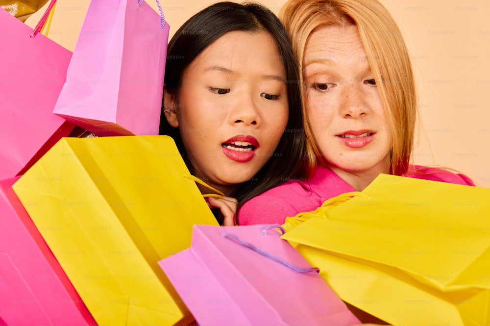 two women looking at each other while holding shopping bags