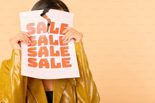 a woman covering her face with a sale sign