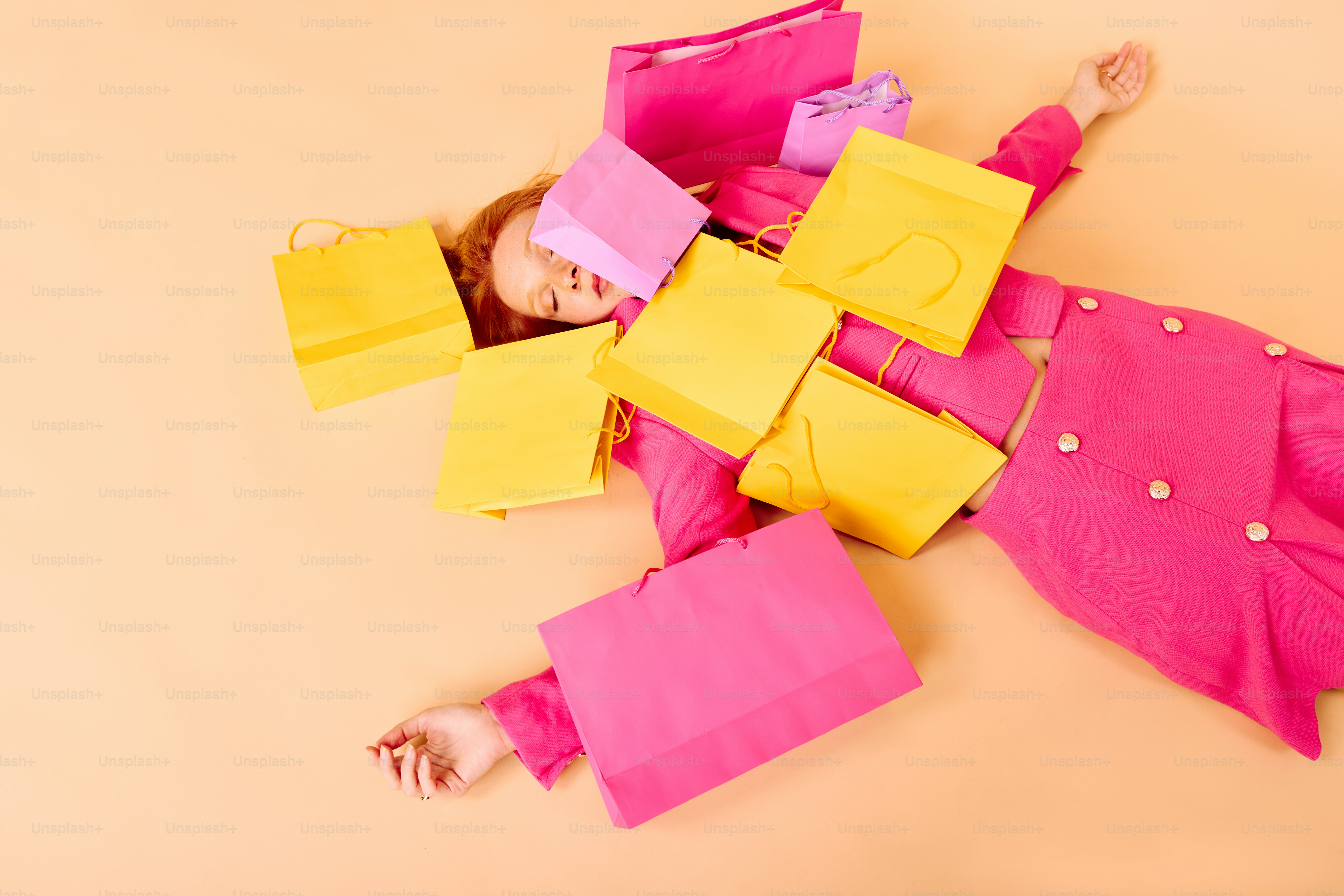a little girl laying on the ground with some paper bags