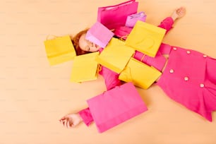 a little girl laying on the ground with some paper bags