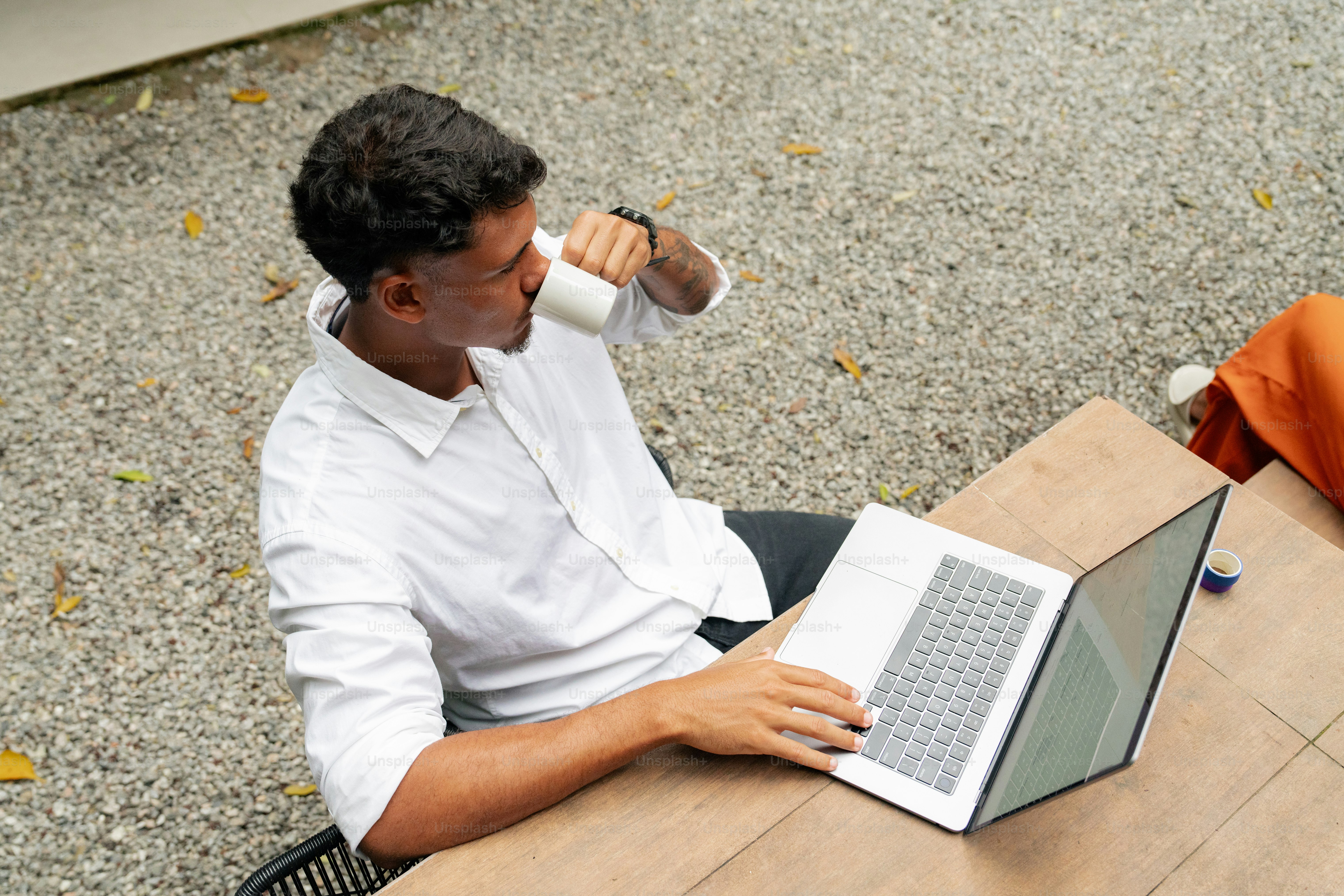 a man sitting at a table using a laptop computer