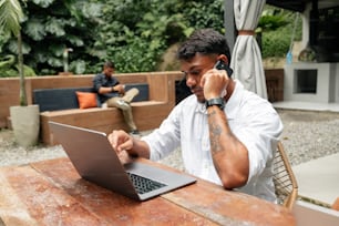Un hombre sentado en una mesa usando una computadora portátil