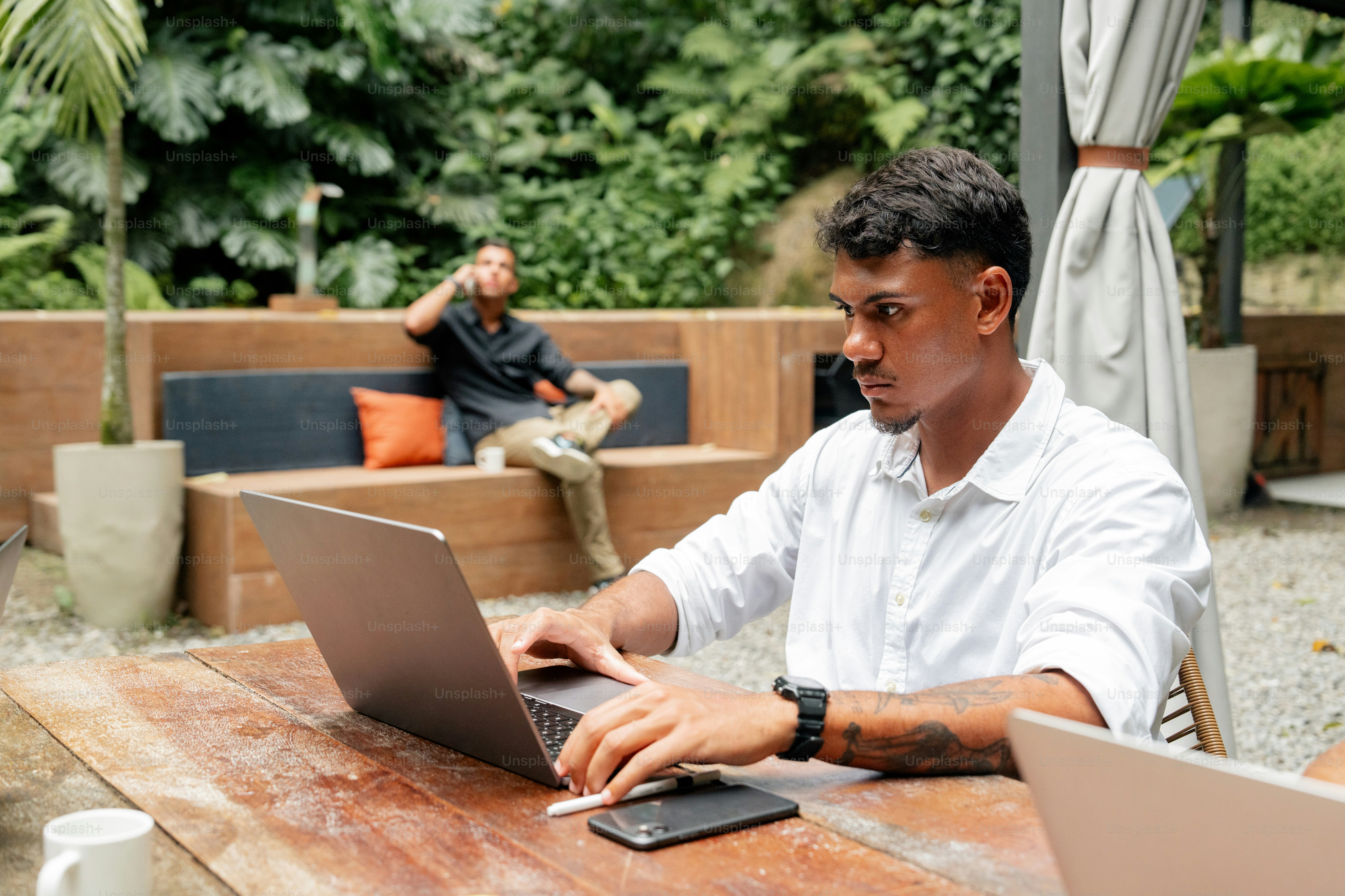 a man sitting at a table using a laptop computer