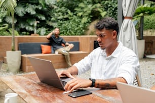 テーブルに座ってノートパソコンを使う男性