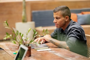 a man sitting at a table using a laptop computer