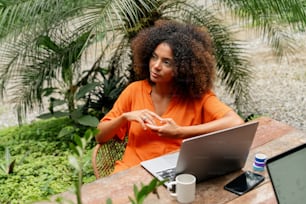 a woman sitting at a table with a laptop