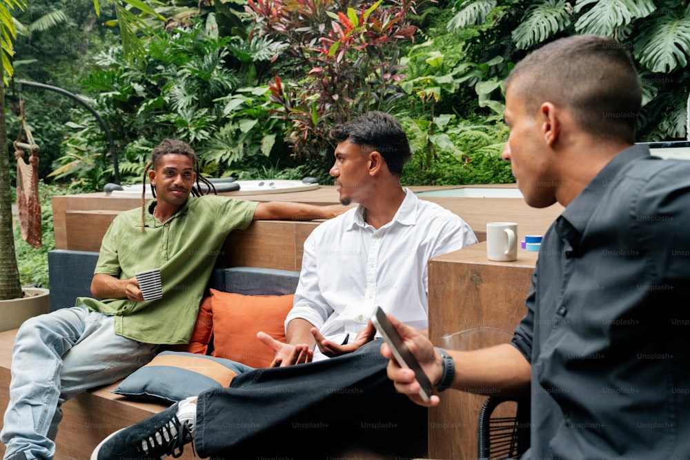 a group of men sitting on top of a wooden bench