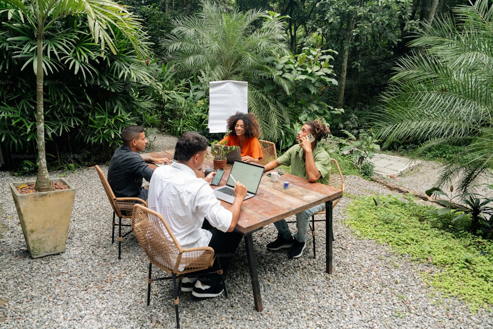 un grupo de personas sentadas alrededor de una mesa de madera