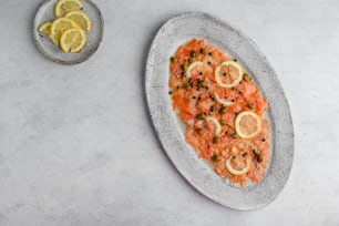 a plate of salmon with lemons and capers