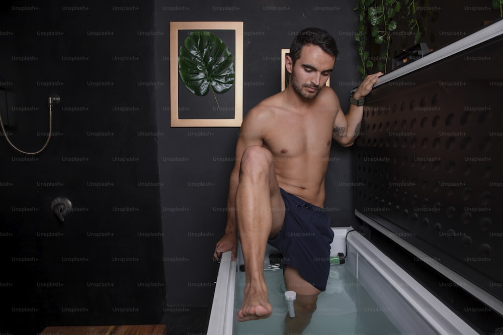 a shirtless man sitting in a bath tub