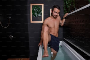 a shirtless man sitting in a bath tub