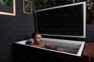 Un hombre sentado en una bañera en una habitación
