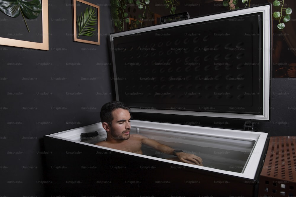 a man sitting in a bathtub in a room