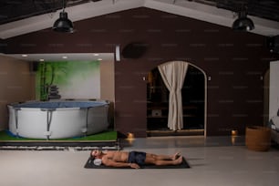 a man laying on a mat in a room