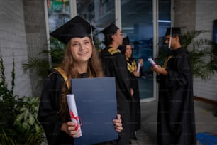 une femme en robe de fin d’études tenant un diplôme