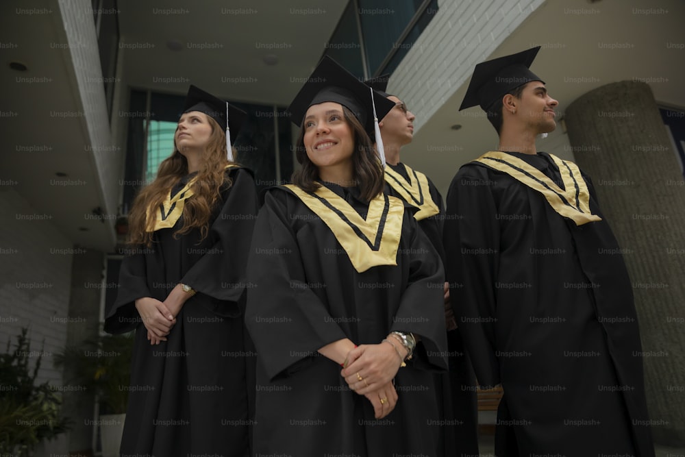 a group of people standing next to each other in graduation gowns