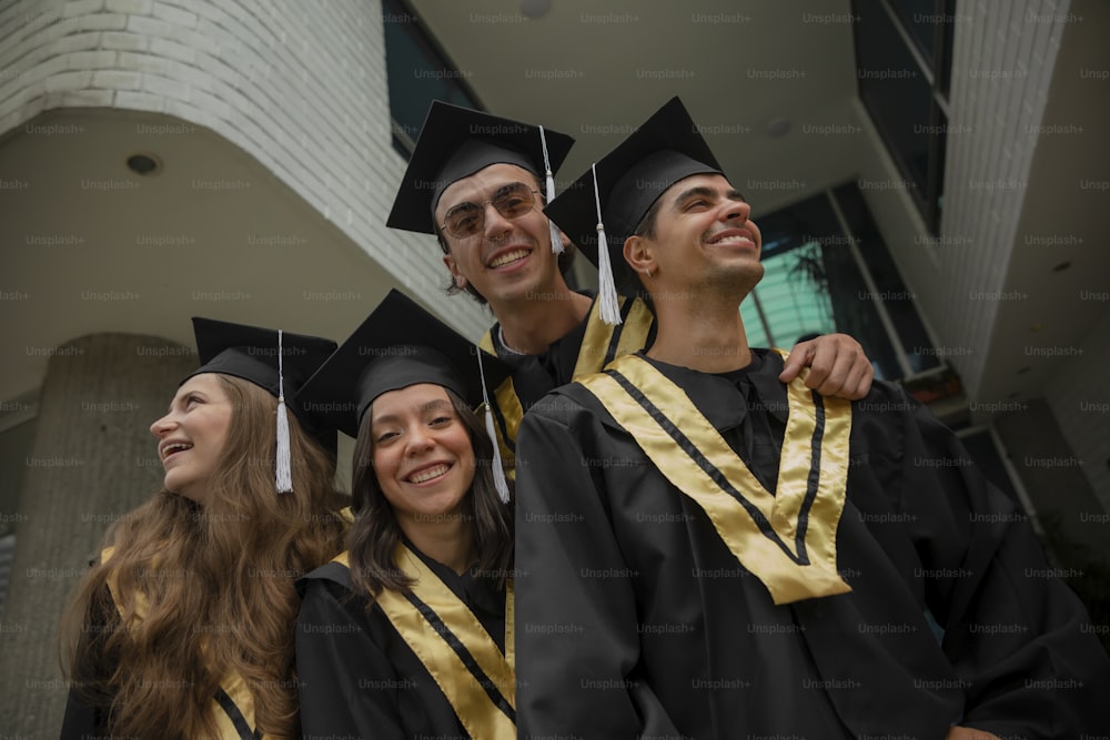 a group of people standing next to each other wearing graduation caps and gowns