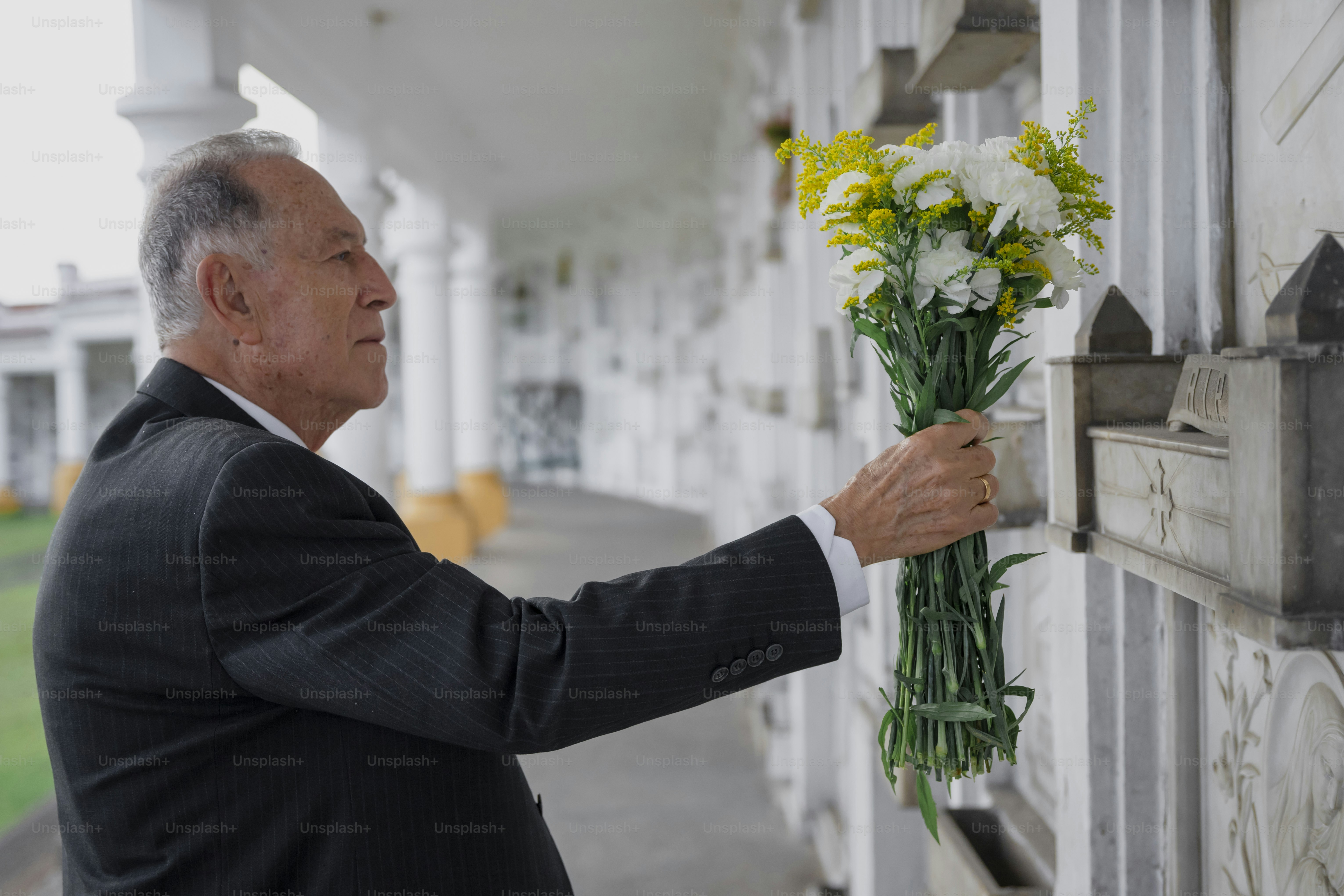 a man in a suit holding a bunch of flowers
