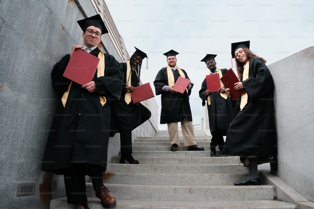 Eine Gruppe von Menschen in Abschlusskleidern steht auf Stufen