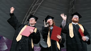 a group of three people in graduation gowns