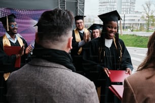 a group of people standing around each other in graduation gowns