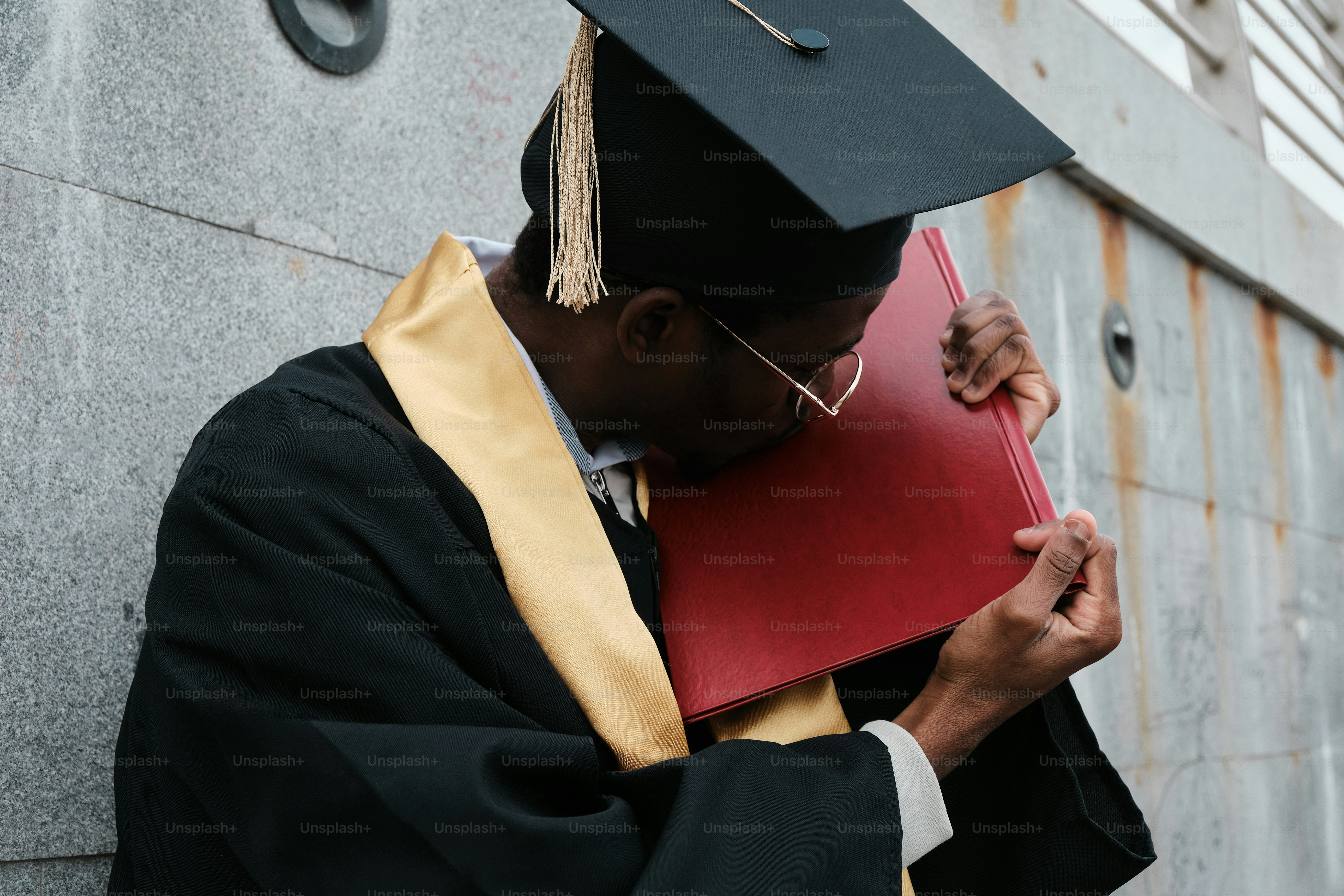 a man in a graduation gown holding a book