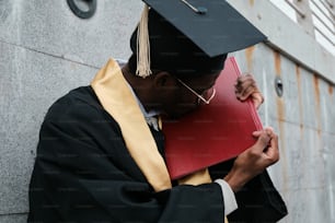 a man in a graduation gown holding a book
