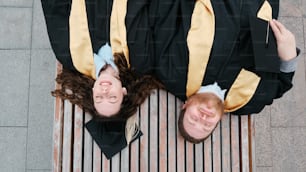 a couple of people laying on top of a bench