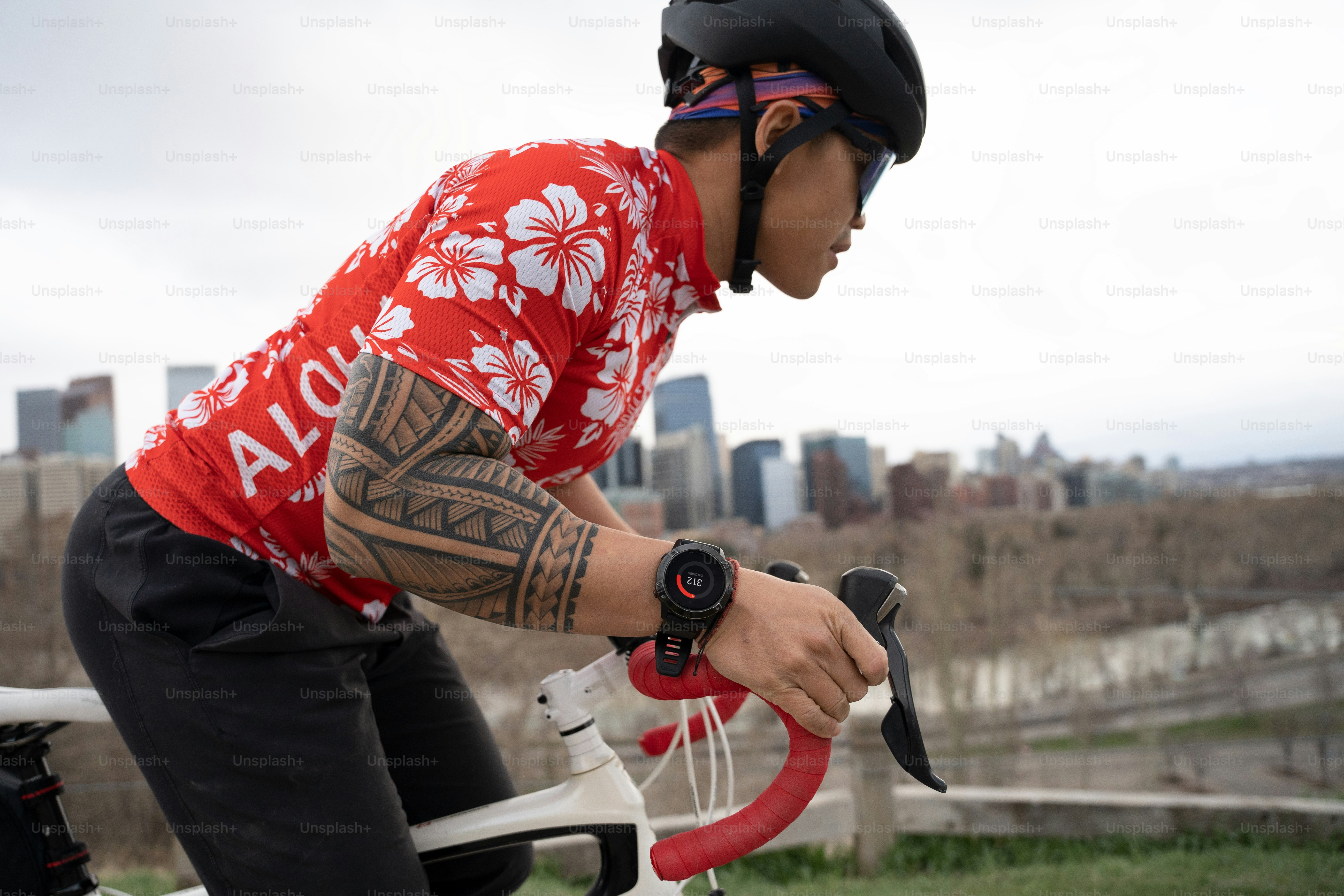 Ein Mann mit einer Tätowierung auf dem Arm fährt Fahrrad