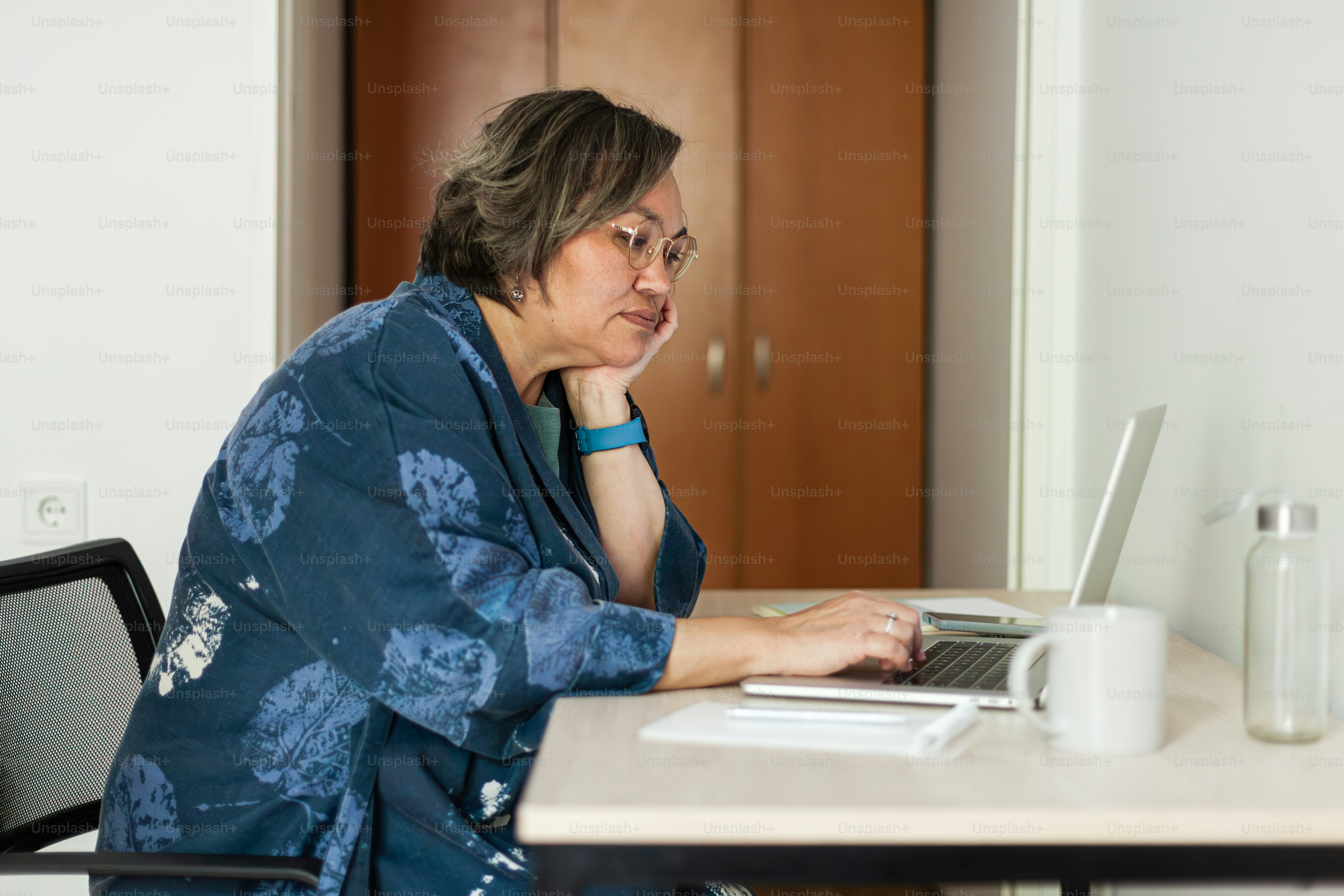 a woman sitting at a table using a laptop computer