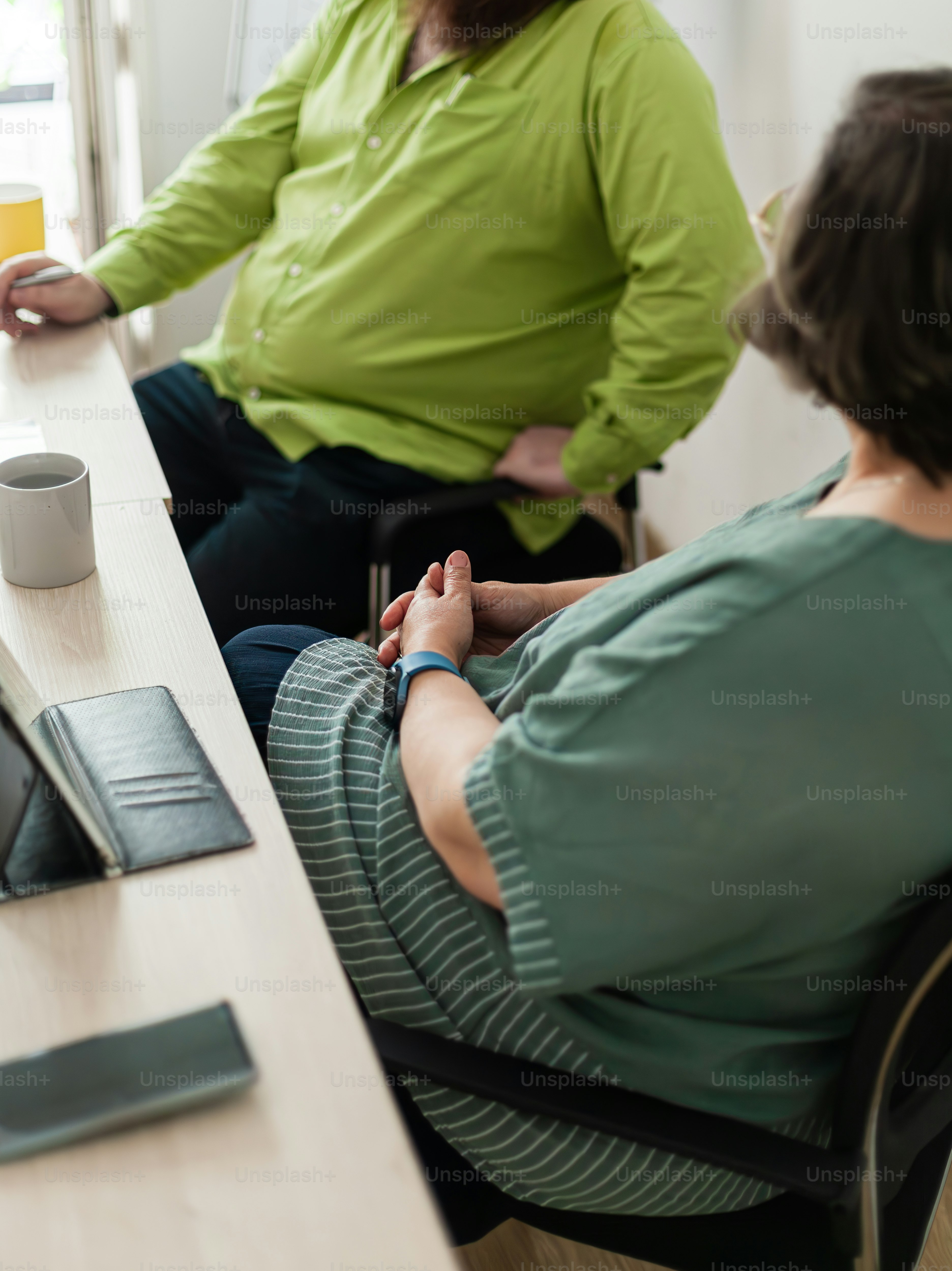 two people sitting at a table with a laptop