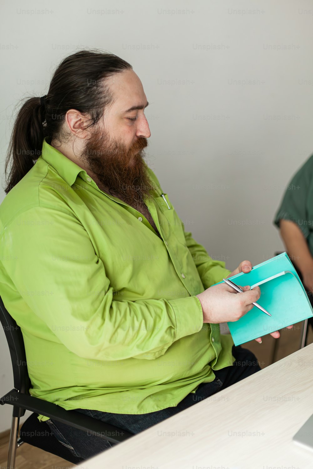 un homme avec une barbe assis à une table