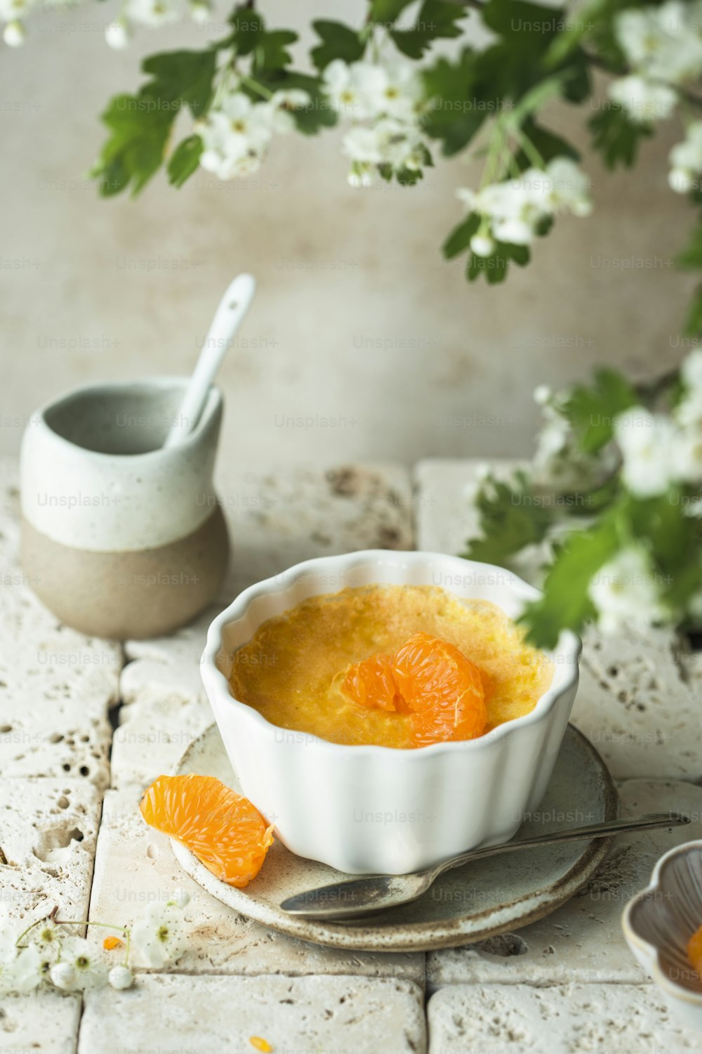 a bowl of orange custard on a plate with a spoon