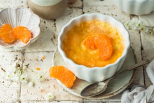a bowl of orange custard on a plate with a spoon
