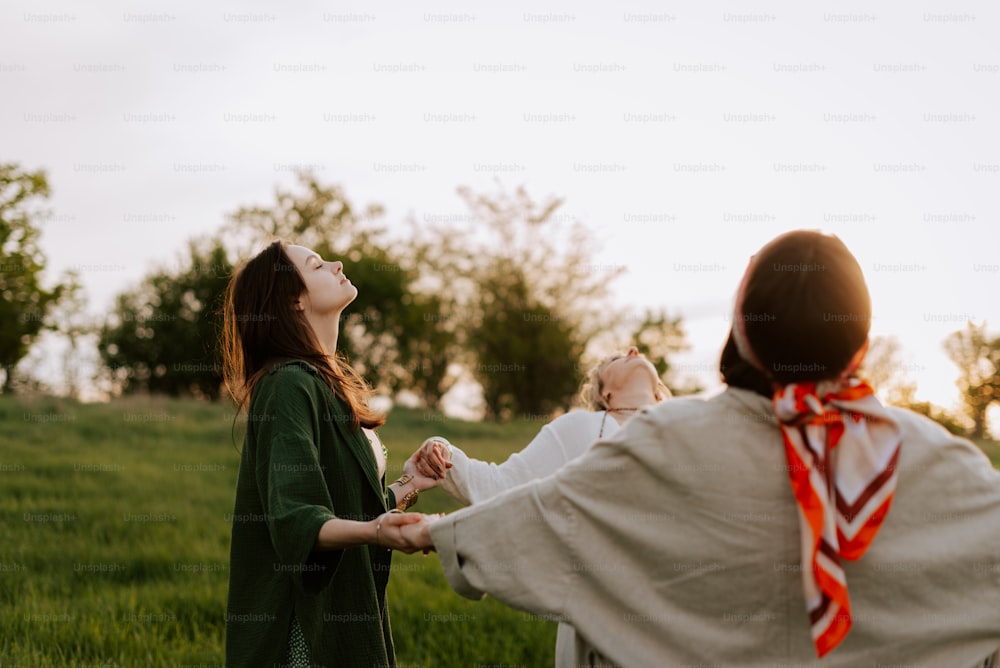 a woman holding a baby in a field