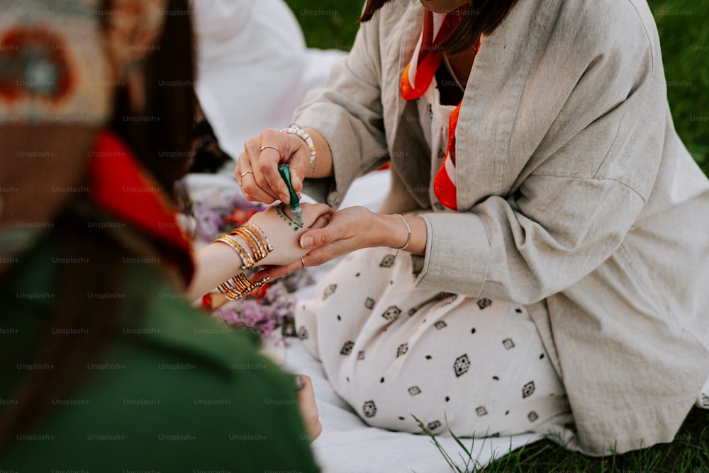 a woman sitting on the ground holding a cell phone