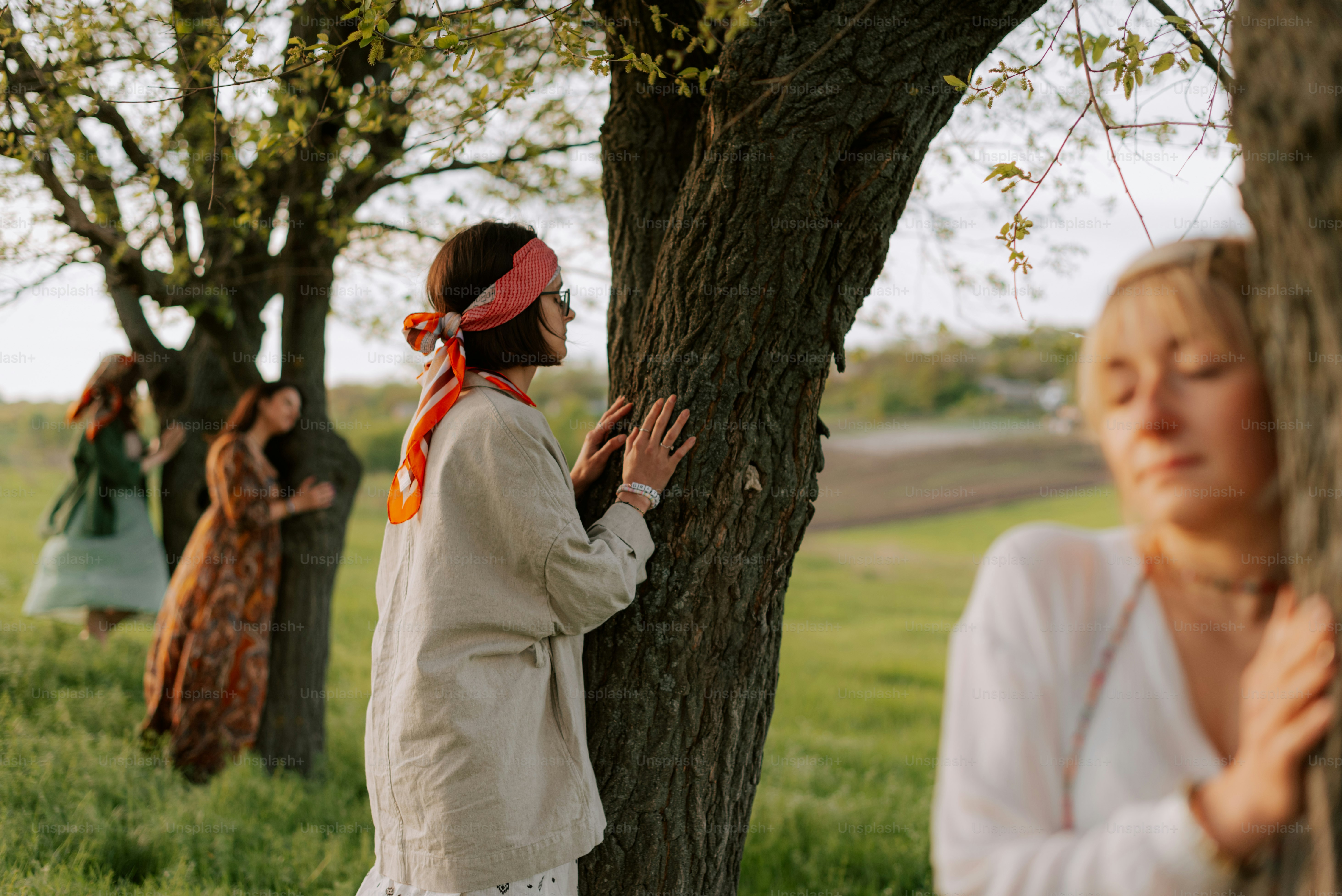 un grupo de mujeres de pie junto a un árbol