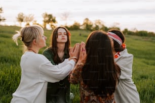 a group of women standing around each other in a field