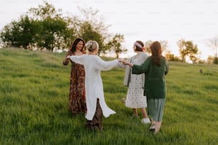 a group of women standing on top of a lush green field