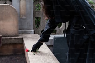 a person placing a flower on a grave