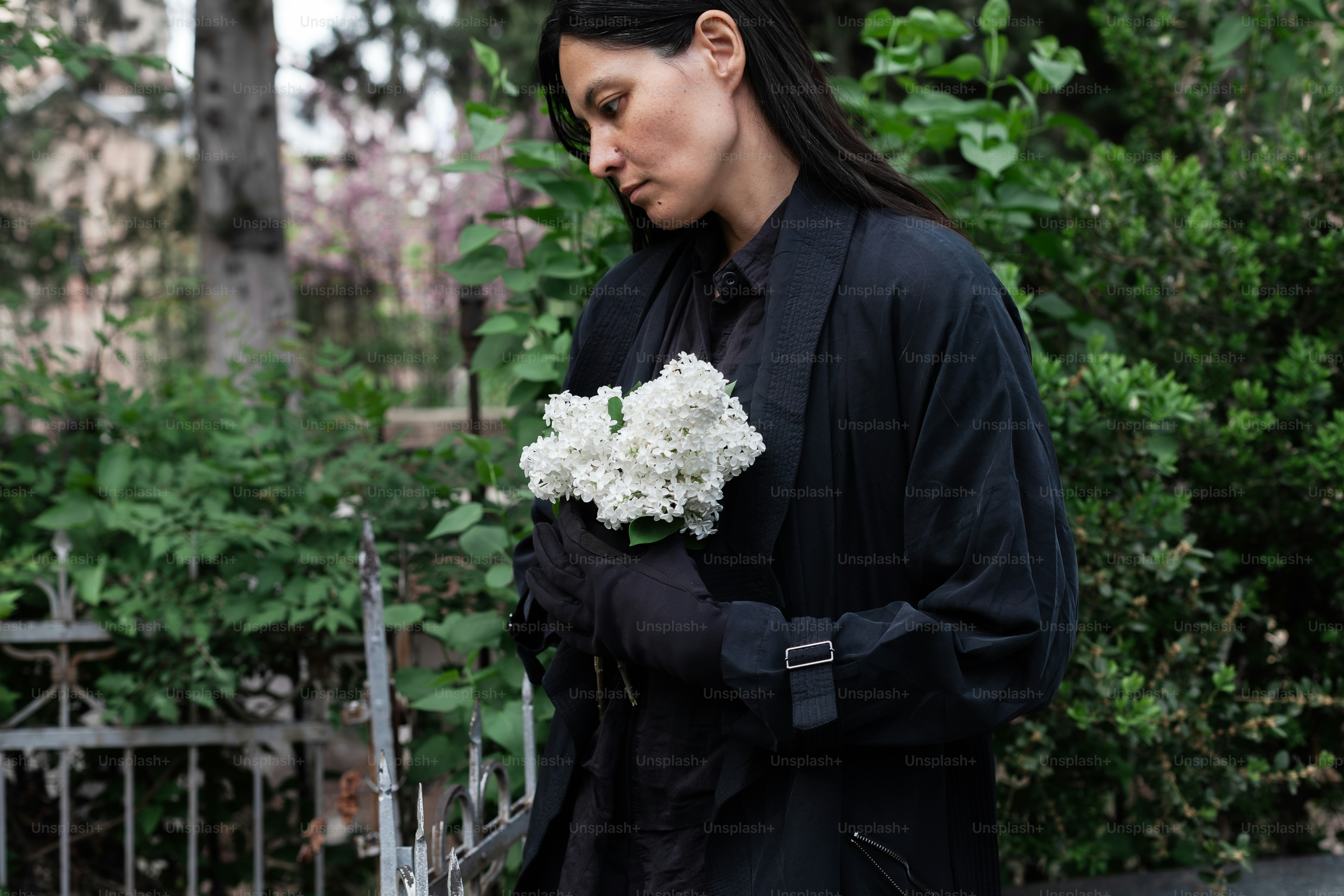 a woman holding a bouquet of white flowers