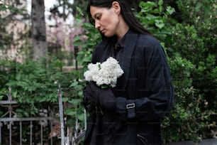 uma mulher segurando um buquê de flores brancas