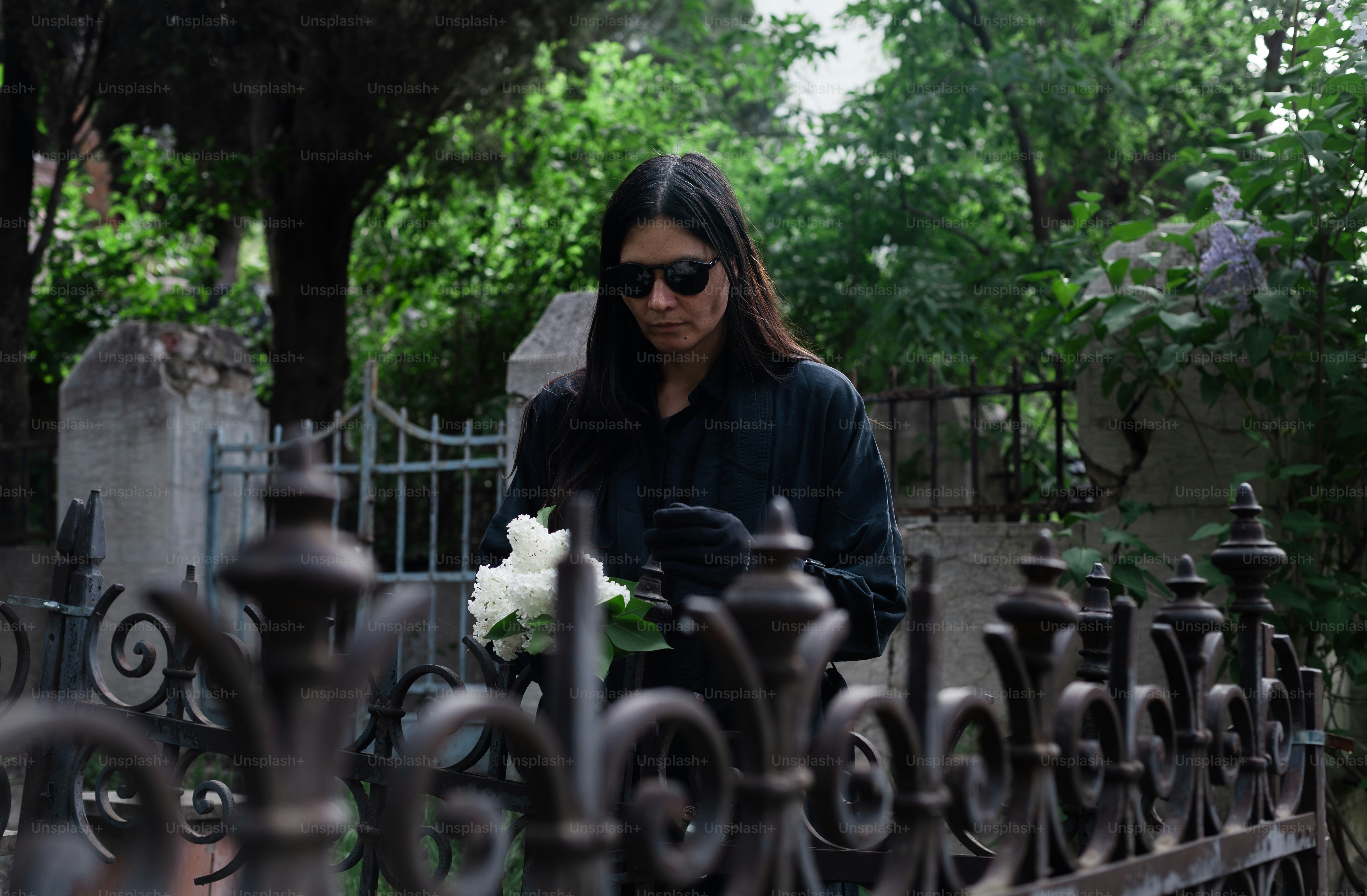a woman with a bouquet of flowers standing in front of a fence